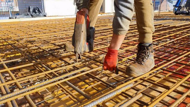 Closeup of steel fixer tying rebar.