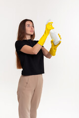 Girl with a sprayer in rubber yellow gloves on a white background. Disinfection, moisturizing.