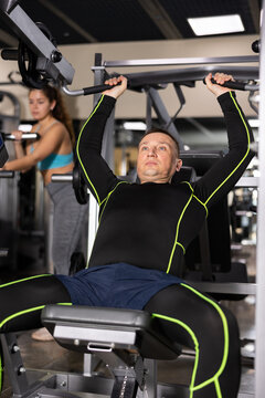 Motivated Athletic Man Exercising On Chest Press Machine During Upper Body Strength Training In Gym