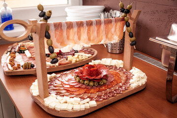 Food decoration on a wooden table. Tasty food on a table. Meat and cheese at the party event.
