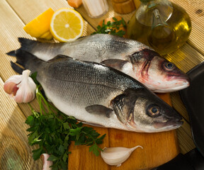 Raw sea bass with lemon, garlic and parsley on cutting board