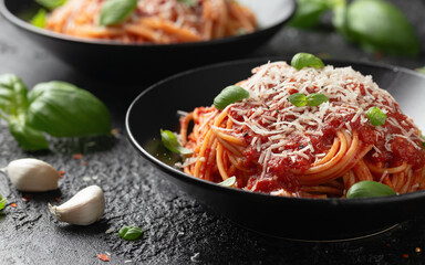 Italian marinara sauce spaghetti pasta served with fresh basil, olives and pecorino cheese