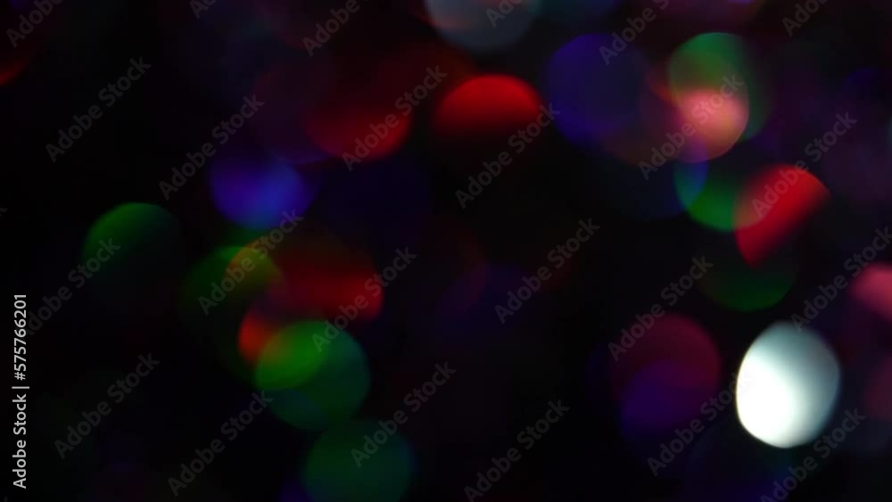 Sticker flowing neon bokeh lights. colorful glowing rainbow confetti transition in front of a black backgrou
