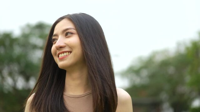 Candid Happy feeling of  Beautiful Young Woman smiling outdoor in sunlight. Pretty face of female and beautiful smile.