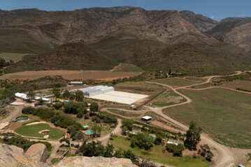 Fototapeta premium Western Cape, South Africa. 2023. New farm building and an area of crops under plastic.