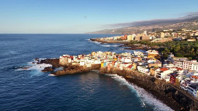 Drohnenaufnahme einer Klippe mit Häusern am Meer, bei Puerto de la Cruz auf Teneriffa, umkreisen