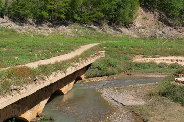 Bridge made of mud with a river of clear water