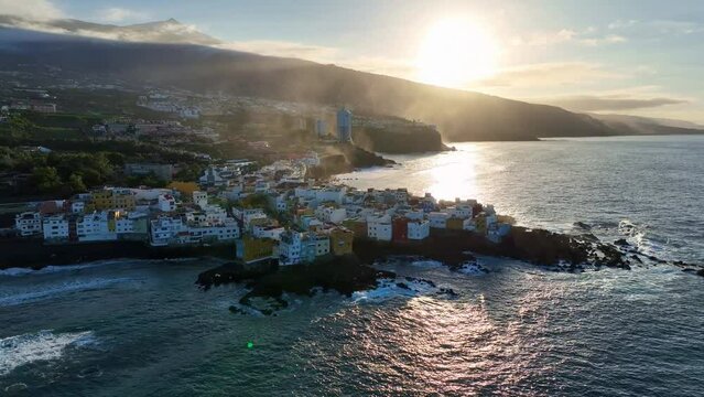Drohnenaufnahme einer Klippe mit Häusern am Meer, bei Puerto de la Cruz auf Teneriffa, umkreisen