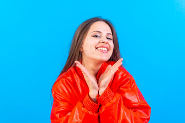 Close up portrait of a young woman, cheerful or laughing isolated on blue studio background