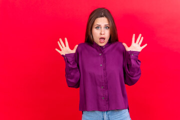 Photo portrait of a scared young woman isolated on a red background