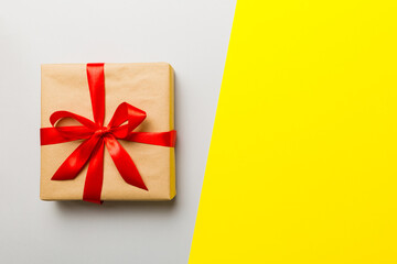 holiday brown paper present tied red ribbon bow top view with copy space. Flat lay holiday background. Birthday or christmas present. Christmas gift box concept with copy space