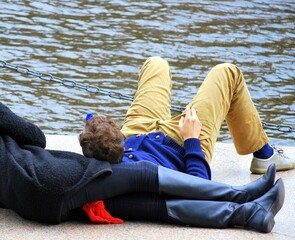 Couple relaxing by the lake outside.