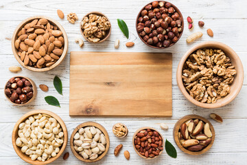 mixed nuts in wooden bowl. Mix of various nuts on colored background. pistachios, cashews, walnuts, hazelnuts, peanuts and brazil nuts