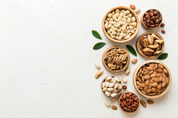 mixed nuts in wooden bowl. Mix of various nuts on colored background. pistachios, cashews, walnuts,...
