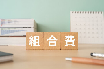 組合費と書かれたブロックが置かれたデスク
