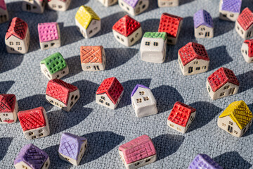 A collection of small houses with different colored roofs on a gray surface.
