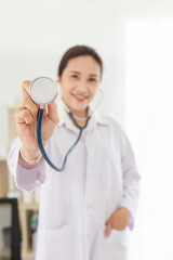 asian doctor holding stethoscope in clinic, she feeling happy and smile in hospital