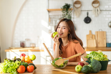 Portrait of beauty body slim healthy asian woman having fun cooking and preparing cooking vegan food healthy eat with fresh vegetable salad in kitchen at home.Diet concept.Fitness and healthy food
