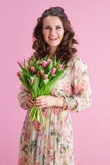 happy elegant woman with long wavy brunette hair on pink