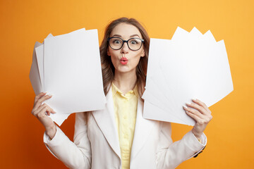 shocked business woman in suit holding documents on orange background, surprised girl manager with papers - obrazy, fototapety, plakaty