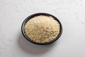 sesame seeds on black plate on white concrete table