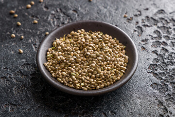 cannabis seeds on black bowl on black concrete table