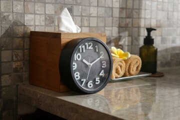 Spa items in beauty spa salon, clock, towels and cosmetic product bottle on the table