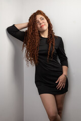 female model posing standing young latin woman with curly red hair, studio with natural beauty, glamorous fashion