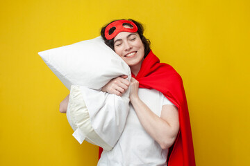girl in superman costume sleeps on soft pillow and rests, the concept of healthy sleep, woman superhero wants to sleep