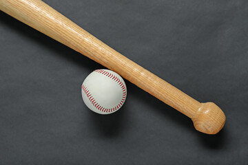 Wooden baseball bat and ball on black background, flat lay. Sports equipment