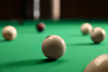 Many billiard balls on green table indoors, closeup