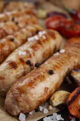 Tasty grilled sausages on wooden board, closeup