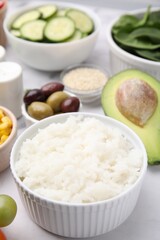 Ingredients for poke bowl on white marble table, closeup