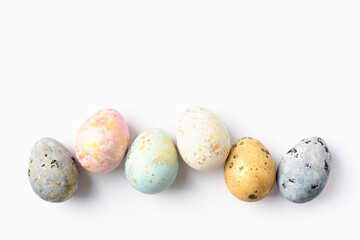 Pastel dyed Easter eggs in row on white. Easter background or greeting card. Copy space.