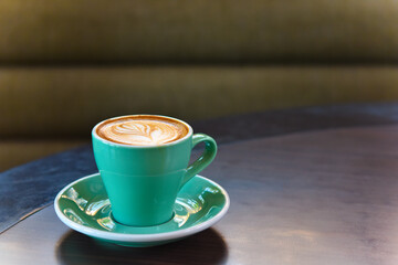 Warm coffee green cup on table with copy space.