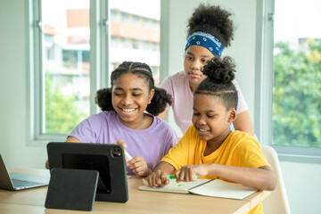 African American junior school kid girl student using digital tablet computer education program app technology during elementary class lesson in classroom.