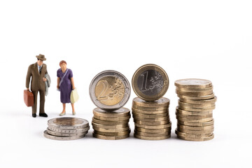Two symbolic figurines of an elderly man and woman and euro coins worth 1 and 2 euros