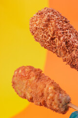 close up of corn dogs on yellow and orange background