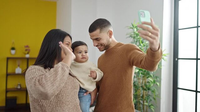 Couple and son make selfie by smartphone standing at home