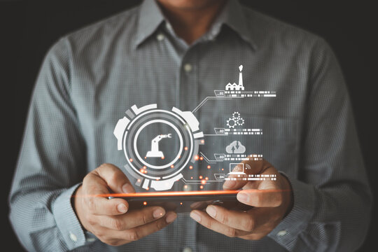 Engineer hands holding a smartphone to check and control automation robot arms machine in intelligent factory industrial on real-time monitoring system software. Smart industry control concept.