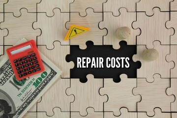 wooden puzzle, caution sign, paper money and calculator with the word repair costs. the concept of...