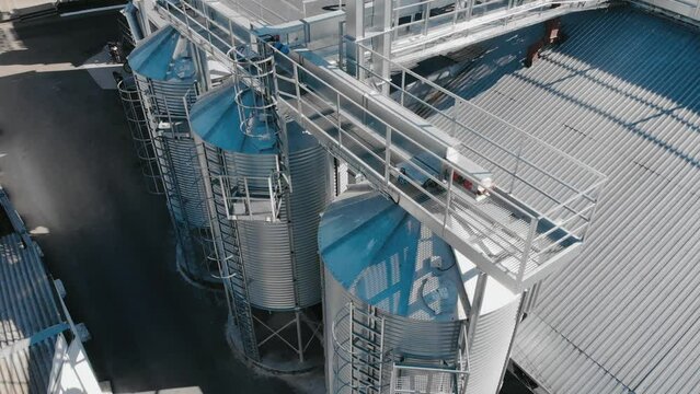 Grain storage aerial view. The camera rises over the steel tanks in the factory.