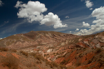 Panorama view of the arid desert and sandstone mountains in a sunny day. Beautiful rock texture and red colors. 
