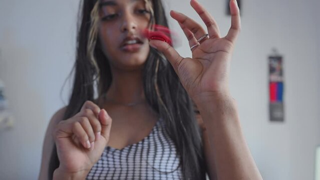 Close up shot of young woman playing with a fidget