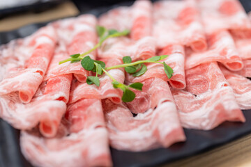 Slice of fresh raw pork at hot pot restaurant