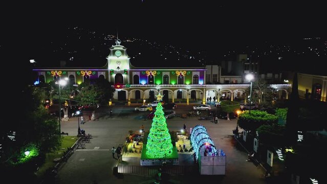 Christmas Tree Illuminated At Night At The Town Square In Front Of City Hall Of Ciudad Guzman, Mexico. - aerial
