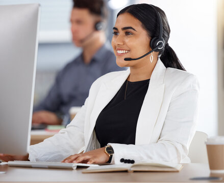 Happy woman, call center and computer with headset in telemarketing, customer service or support at office. Friendly female consultant or agent with mic sitting by desktop PC in contact us for sales