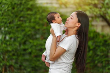 Fototapeta premium mother holding with her baby newborn in garden