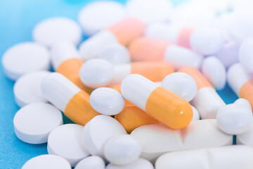 White and orange pills or capsule freely laid on a table.