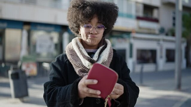 Young african american woman showing empty wallet at street